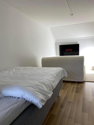 una camera bianca con letto e televisore di Luxury - Sauna With Star Lights - WiFi&Parking a Rovaniemi
