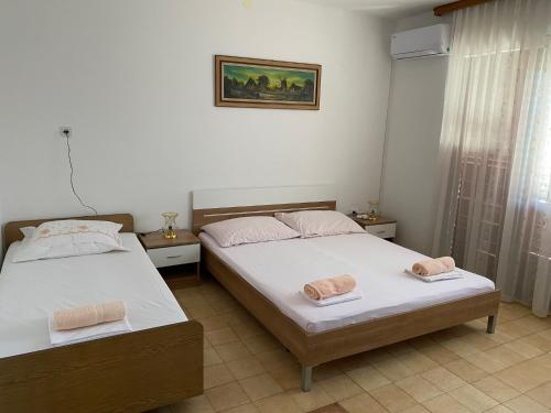 - 2 lits dans une chambre avec 2 serviettes dans l'établissement Apartmani Infinity, à Sukošan