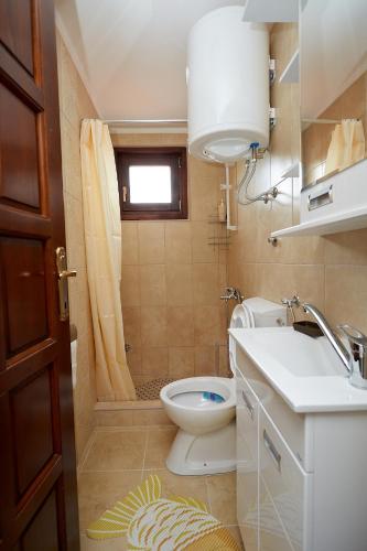 a bathroom with a toilet and a sink and a window at Apartmani ,,Vasa ,, 2 in Soko Banja