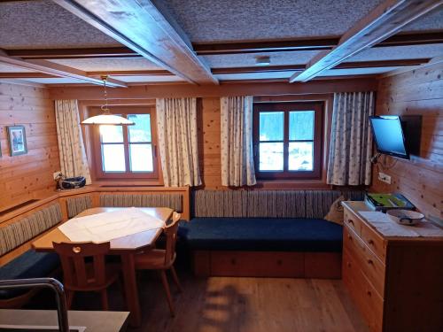 ein Esszimmer mit Tisch und Fernseher in der Unterkunft Plonerhof in Hopfgarten in Defereggen