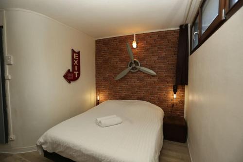 - une chambre avec un lit et un mur en briques dans l'établissement Loft Indus, à Chamalières