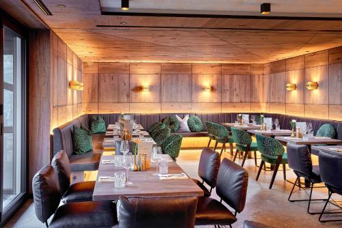 a restaurant with wooden walls and tables and chairs at Hotel Neue Post in Mayrhofen