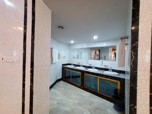 a bathroom with two sinks and a large mirror at Hotel Sea World Cox's Bazar in Cox's Bazar