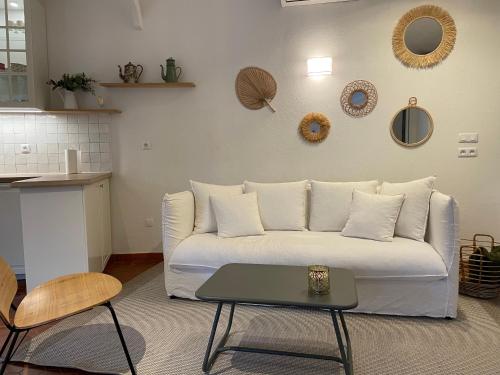 ein Wohnzimmer mit einer weißen Couch und einem Tisch in der Unterkunft Villa bord de mer in Torreilles