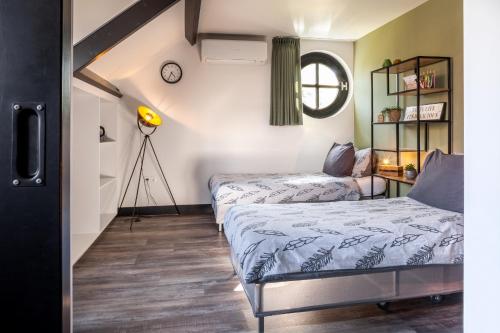 a bedroom with two beds and a mirror at B&B La Vita Verde in Susteren