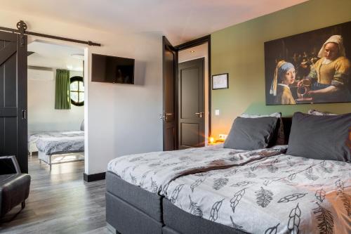 1 dormitorio con 1 cama y una pintura en la pared en B&B La Vita Verde, en Susteren