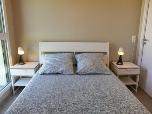 une chambre avec un grand lit avec deux tables de nuit dans l'établissement Maison neuve lumineuse avec jardin, parking privé, à Saint-Valery-sur-Somme