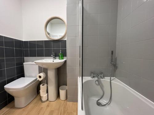 ein Badezimmer mit einem Waschbecken, einem WC und einer Badewanne in der Unterkunft Glasgow 2 Bedroom Apartment in Glasgow
