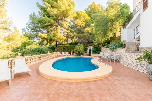 a pool in a backyard with chairs and a table at Fantastisic villa - Great location in Moraira