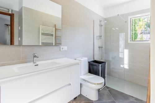 a white bathroom with a sink and a toilet at Fantastisic villa - Great location in Moraira