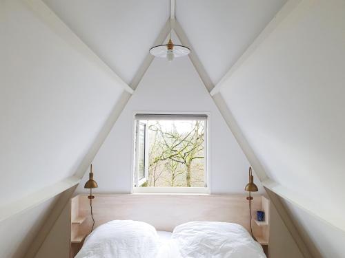 a bedroom with a bed and a window at Modern A-Frame vakantiehuis Durbuy Ardennen in Durbuy