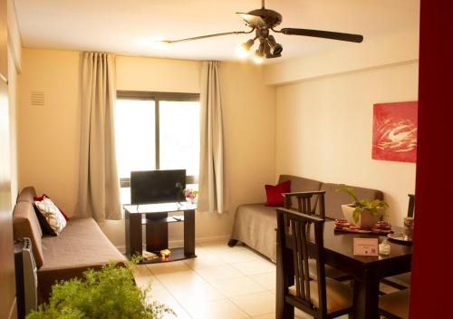 een woonkamer met een bank en een tv bij Uvas Apart Hotel in Mendoza