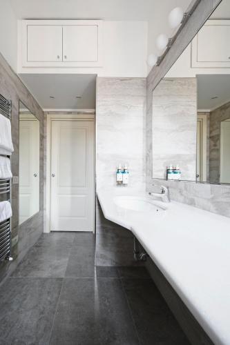 a bathroom with a large white sink and a mirror at Numa Milan Loreto in Milan