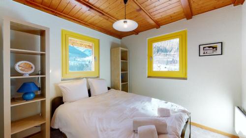 a bedroom with a white bed and a chair at Chalet in the heart of the Val d'Anniviers resort in Saint-Jean