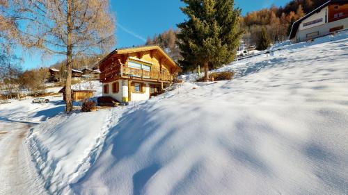 a house on a snowy hill with a pile of snow at Chalet in the heart of the Val d'Anniviers resort in Saint-Jean