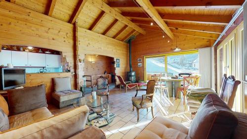 a living room with a couch and a table with chairs at Chalet in the heart of the Val d'Anniviers resort in Saint-Jean