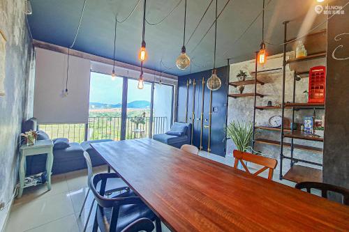 a dining room with a large wooden table and chairs at Miko's studio at Trefoil Setia Alam in Setia Alam