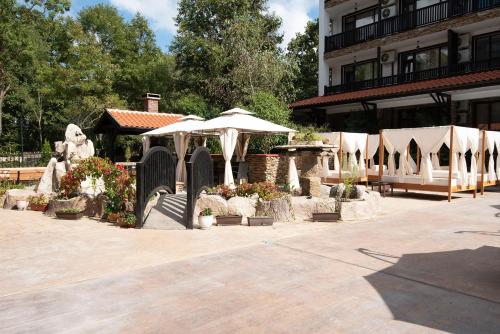 a group of tables with umbrellas in a courtyard at The Green Paradise Apartments in Primorsko