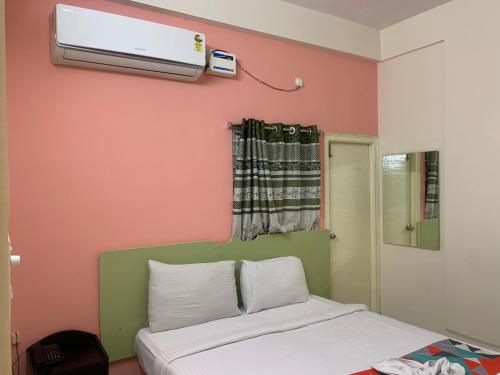 um quarto com uma cama e ar condicionado na parede em Homewood Suites ( Service Apartments) em Hyderabad