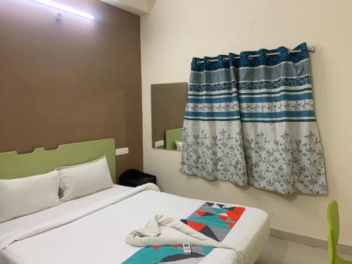 a bedroom with a bed and a curtain at Homewood Suites ( Service Apartments) in Hyderabad