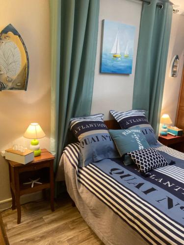 um quarto com uma cama com cortinas azuis em La Fossette em Asnelles