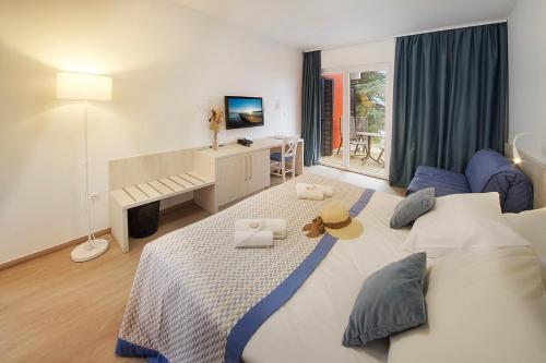 a bedroom with a large bed and a desk at Villa Adriatic - Hotel & Resort Adria Ankaran in Ankaran