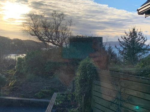 a view of a garden from a window of a house at Corrie House in Craobh Haven
