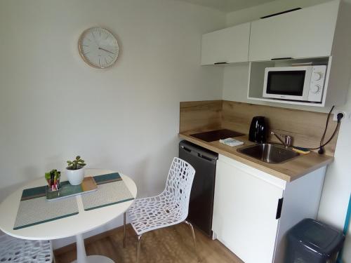 a small kitchen with a table and a sink at L alouette in Égletons