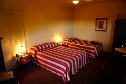 two beds in a room with two lamps on them at Muswellbrook Northside Bed & Breakfast in Muswellbrook