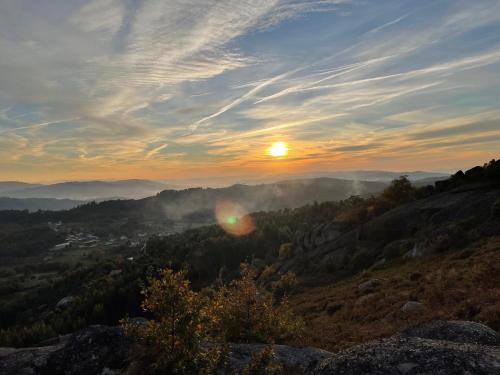 a sunset in the mountains with the sun setting at quinta da quinta, private room in Vieira do Minho