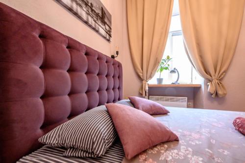 a bedroom with a large padded headboard and pillows on a bed at Уютная квартира недалеко от Дерибасовской in Odesa