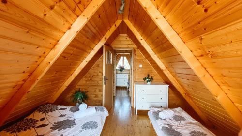 a attic room with two beds in a log cabin at Domki Bałtyckie in Władysławowo