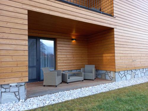 a patio with two chairs on a wooden deck at Apartmány Tatry Žiarce in Liptovský Mikuláš