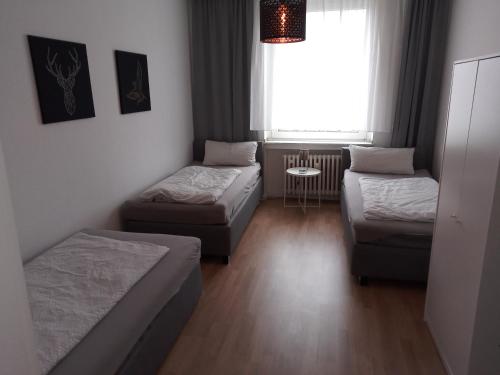 a room with two beds and a couch and a window at Wohnung in Köln in Cologne