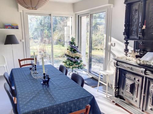 une salle à manger avec une table bleue et un arbre de Noël dans l'établissement Le mur des beaunes, à Pruniers