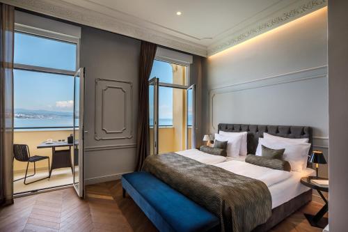 a bedroom with a large bed with a large window at Hotel Ambasador - Liburnia in Opatija