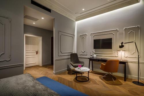 a room with a desk and two chairs and a television at Hotel Ambasador - Liburnia in Opatija