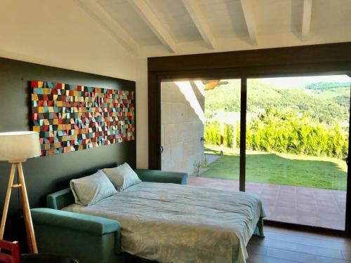 1 dormitorio con 1 cama y puerta corredera de cristal en Casa Nueva de Vigo con Jacuzzi y chimenea, en Mos