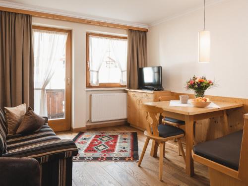 a living room with a table and a tv at alpina&more APARTMENTS I ZIMMER in Serfaus