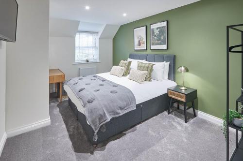 a bedroom with a bed and a green wall at Host & Stay - Littlebeck House in Sleights