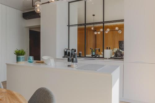 uma cozinha com um balcão branco num quarto em Apartament 309 em Boszkowo