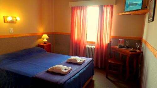 ein Hotelzimmer mit einem Bett und einem Fenster in der Unterkunft Hotel Koi Mahik in El Calafate