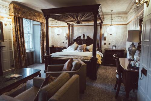 a bedroom with a canopy bed and a couch at Royal Oak Hotel in Betws-y-coed