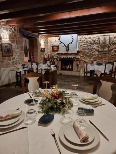 a table with plates of food and a fireplace at Posada Torre Palacio La Taxuela in Villanueva la Lastra