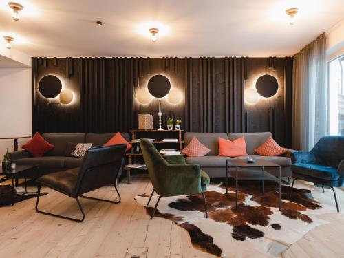 a living room with a couch and chairs at alpina&more APARTMENTS I ZIMMER in Serfaus