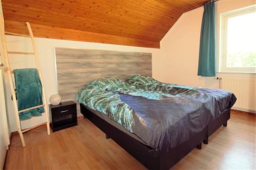 Sint-Oedenrode的住宿－'t Hoefijzer，一张位于带木制天花板的客房内的大床