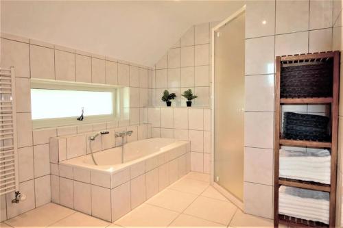 Sint-Oedenrode的住宿－'t Hoefijzer，白色的浴室设有浴缸和水槽。