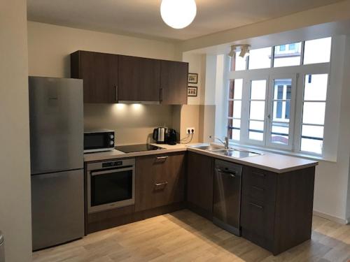 d'une cuisine équipée d'appareils en acier inoxydable et d'une fenêtre. dans l'établissement Gîte Louise de la Maison saint-Josse, à Colmar