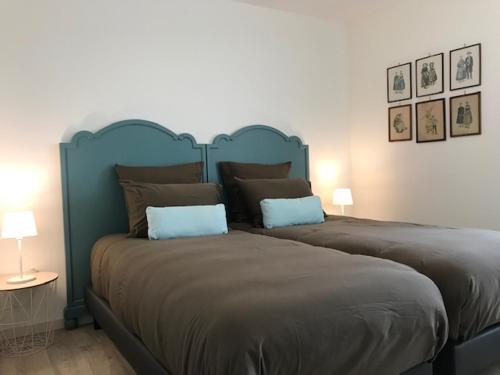 un grand lit avec une tête de lit bleue dans une chambre dans l'établissement Gîte Louise de la Maison saint-Josse, à Colmar