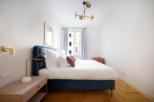 Un dormitorio con una cama azul y blanca y una mesa en numa I Loreto Apartments en Milán